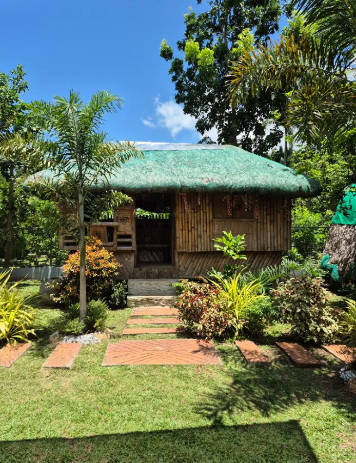 Nipa-roof bamboo kubo in a tropical garden