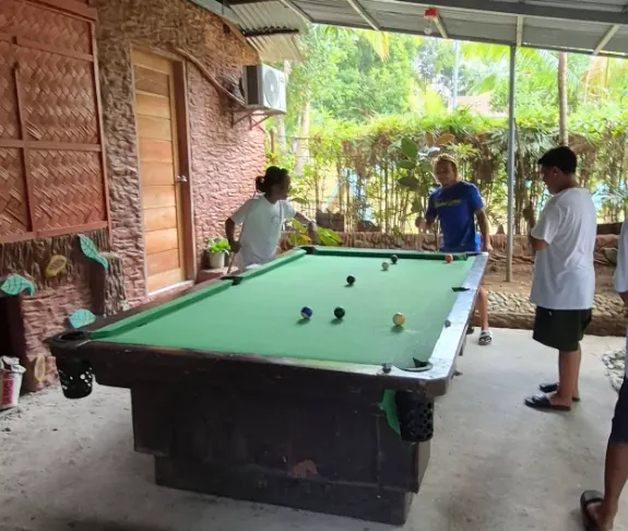 Guests playing billiards in the covered lounge