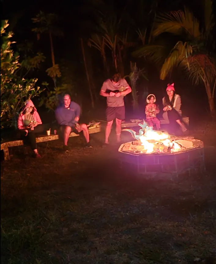 Family gathered around the bonfire at night