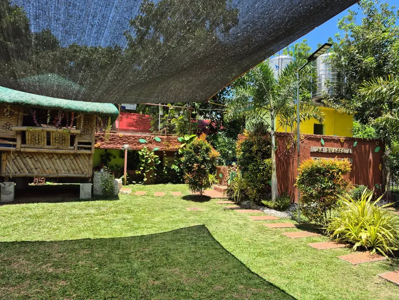 Native bamboo kubo in a landscaped garden with stepping stones